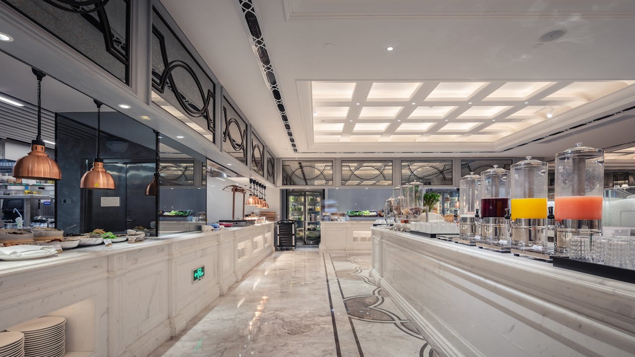 home-img Luxurious hotel buffet area featuring elegant interior design and a variety of juices.